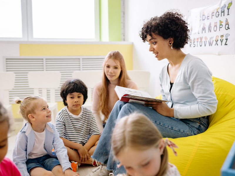 Teacher reading to a group of children in a classroom setting