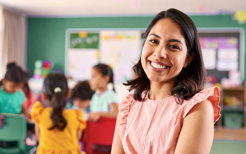 Teacher smiling in a classroom with students